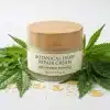 Cosmetica cannabis con crema reparadora de cáñamo y CBD sobre hojas.