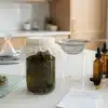 Proceso de elaboración de tinturas de cannabis con frascos, colador y goteros.